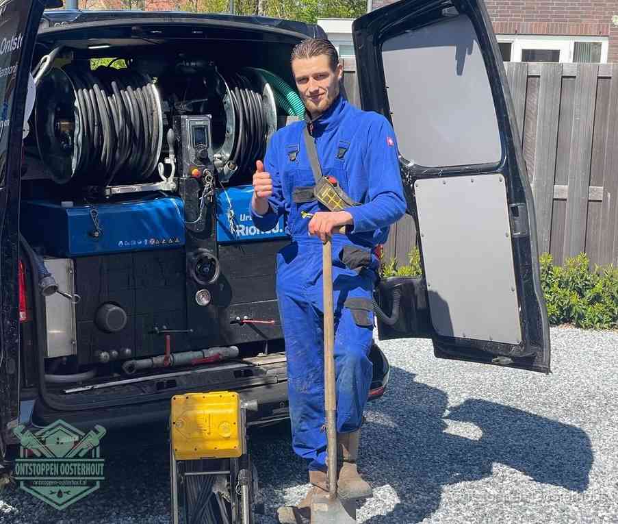 Een tevreden monteur met opgestoken duim naast de bestelbus, slim ingrijpen bespaart kosten bij een verstopte afvoer in Oosterhout