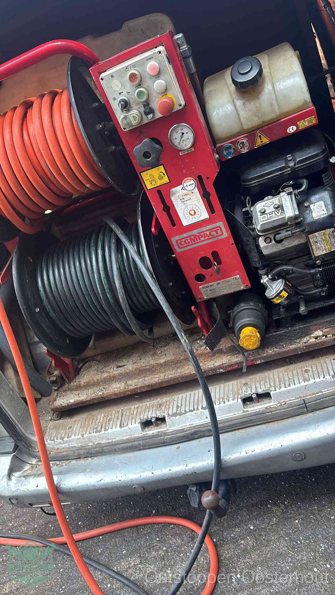 Een rood hogedruk-rioolreinigingstoestel in de laadbak van de bedrijfsbus, apparatuur voor een hardnekkige afvoerverstopping in Oosterhout
