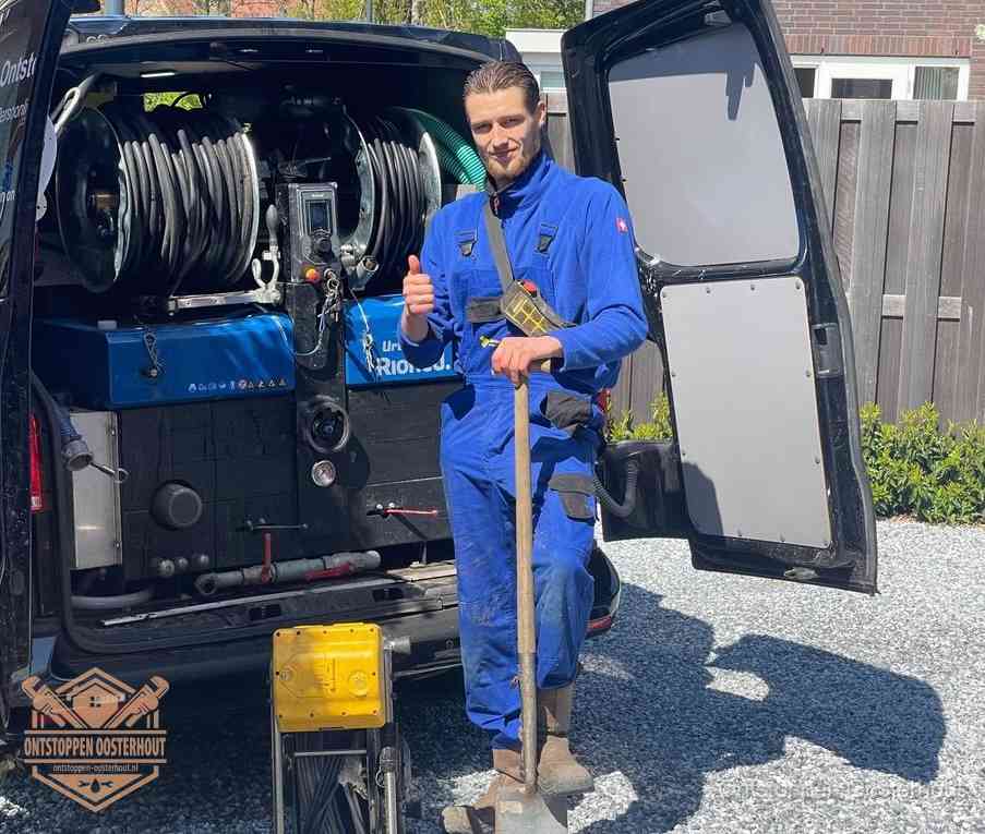 Een monteur bij de werkbus met grote hogedruk-slanghaspels, apparatuur voor hardnekkige afvoerverstoppingen in Oosterhout