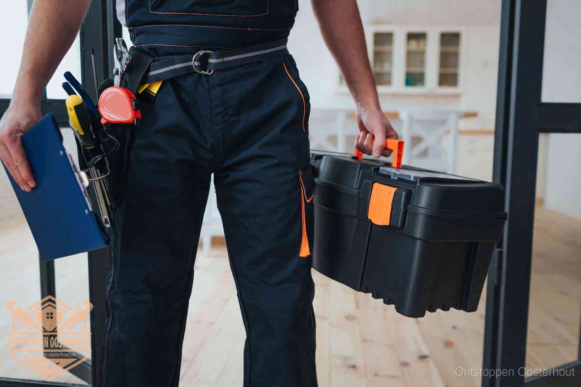 Een monteur met gereedschapsriem en klembord in een keuken, klaar om een transparante prijs voor het gootsteen ontstoppen in Oosterhout te geven