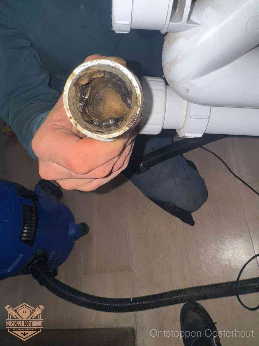 Een losgekoppelde afvoerbuis die van binnen volledig is dichtgeslibd met vet en aanslag, de meest voorkomende oorzaak van een verstopte gootsteen in Oosterhout