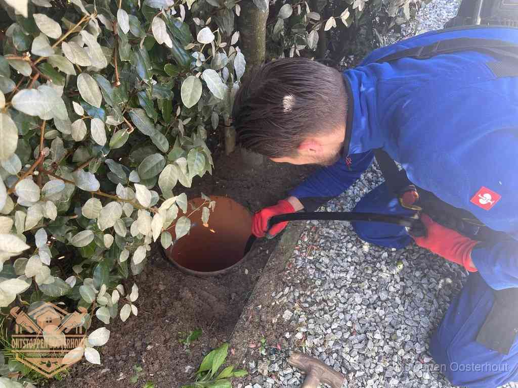 Monteur reinigt een rioolput met een slang, periodieke rioolreiniging in Oosterhout
