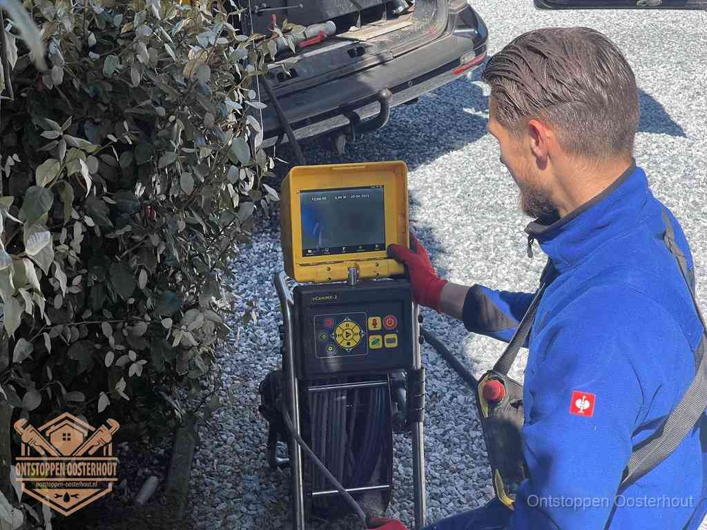 Monteur bedient een rioolinspectiecamera met monitor voor rioolinspectie in Oosterhout
