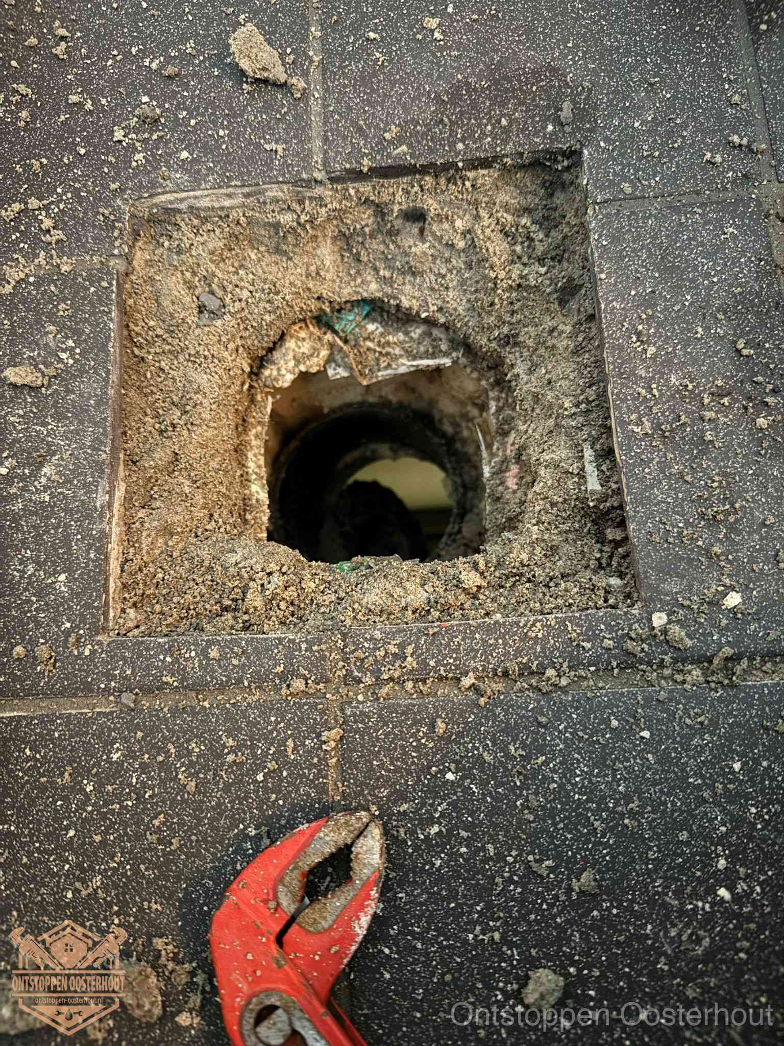 Geopend rioolputje op de erfgrens dat laat zien wie eigenaar is van de riolering in Oosterhout