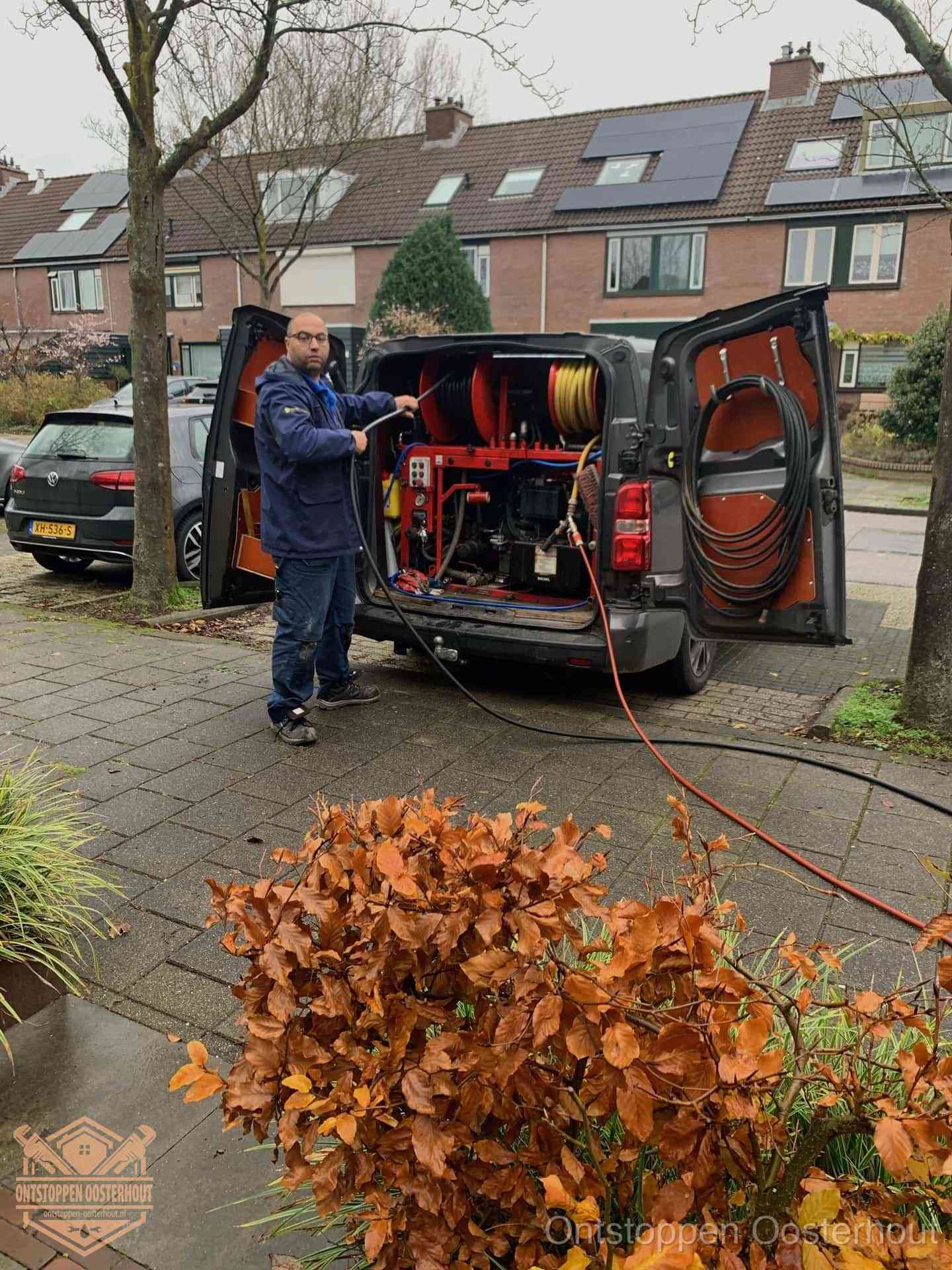 Monteur met rioolreinigingsbus levert rioolservice in de wijk in Oosterhout