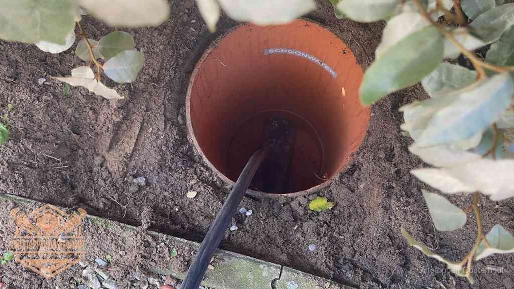 Open inspectieput in de tuin waar een veer rioolvliegjes en stankoverlast aanpakt in Oosterhout
